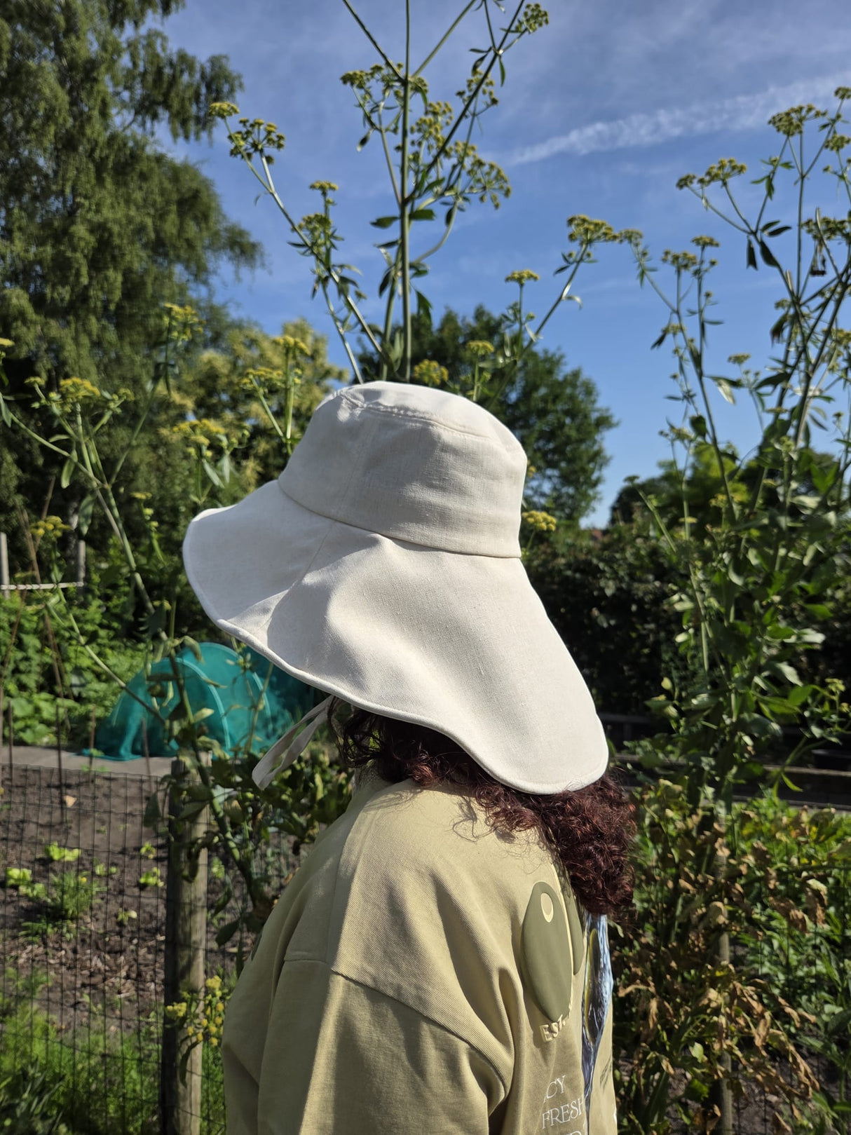 Stay cool while tending your garden with this elegant linen wide brim sun hat. Made from breathable linen, with a full face and neck coverage, perfect for sunny days among your veggies and flowers, or simply enjoying your garden. The adjustable chin strap keeps it secure on breezy afternoons, making it your ideal companion for every garden adventure." Available in beige and camel